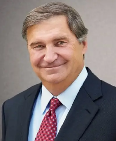 A man in suit and tie smiling for the camera.